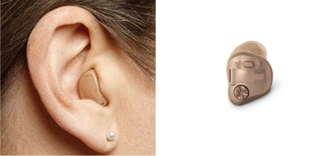 Małe aparaty słuchowe douszne typu ITE, które lekko wystają z ucha i są wyposażone w bezprzewodowe połączenie bluetooth.