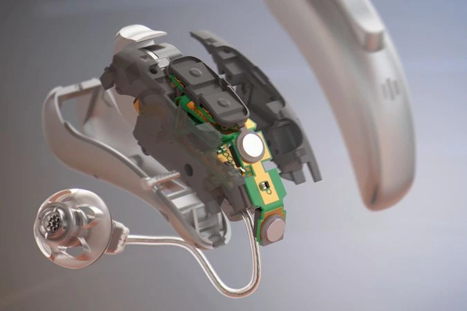 Budowa cyfrowych aparatów słuchowych Signia, która przedstawia mikrofony oraz wzmacniacz dźwięku jako kluczowy element tego urządzenia.